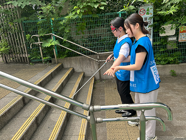 白杖を用いて階段を上る姿